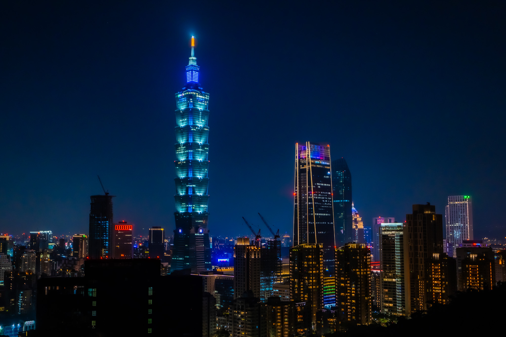 Taipei skyline at night with Taipei 101 lit in blue